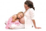 Little girl listen her mother belly. Isolated on white.